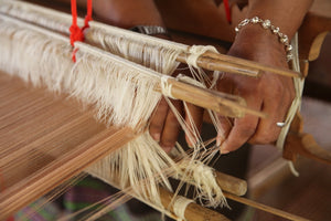 Hand weaving cotton on traditional wooden loom