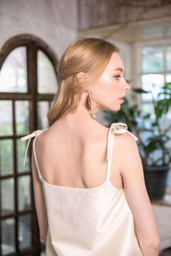 Image shows the back detailing for the top of The Dawn Co Ord set in cream by Rare & Fair. The silk two piece set can be worn together or individually. The pure silk fabric is handmade by Thai artisans on traditional wooden looms 