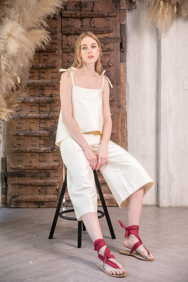 Model sitting down wearing The Dawn Co Ord Set in cream. The pure silk fabric is hand crafted by artisans for Rare & Fair